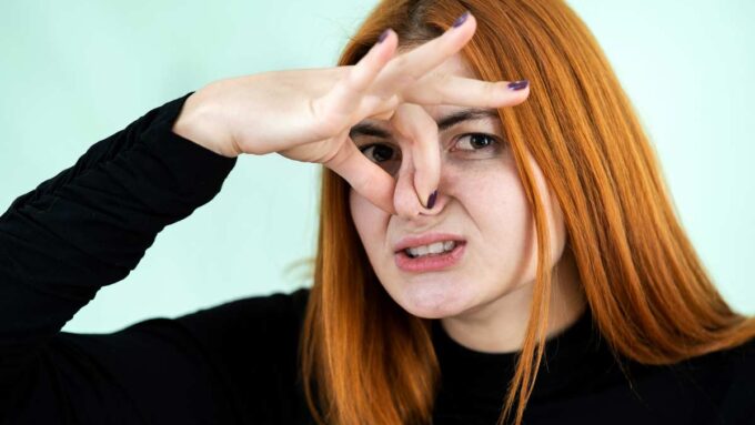 woman pinching nose shut